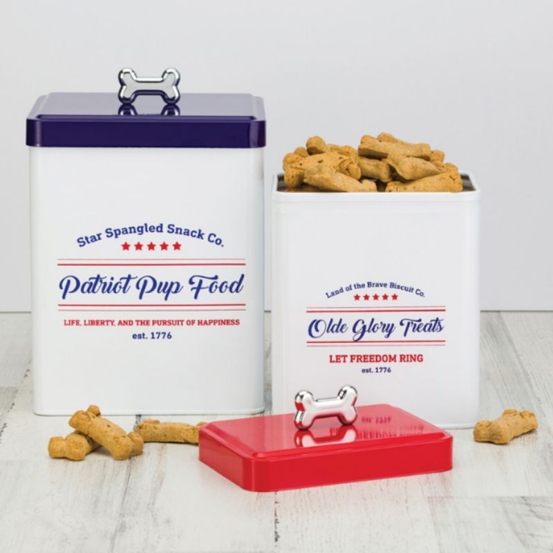 This Patriotic Pup Food Tin is an American-inspired metal food storage container. Featuring a navy-blue lid with a silver bone shaped handle with decorative lettering.